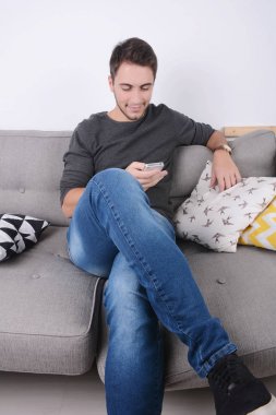 Kanepeye Smartphone kullanan adam.