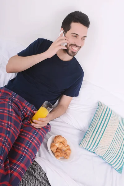 Yatakta telefonda konuşan adam.