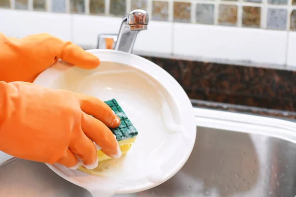 Manos en guantes de goma lavando platos con spon —  Fotos de Stock