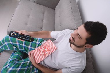 Patlamış mısır yemek ve film izlerken bir adam.