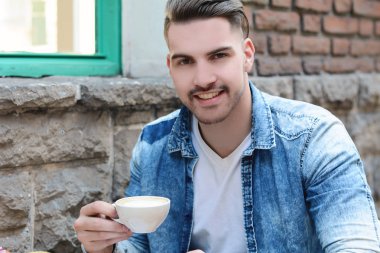 Kaldırım café'de oturan adam