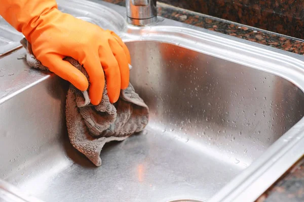 Mano con guantes limpiando fregadero de acero inoxidable con tela — Foto de Stock