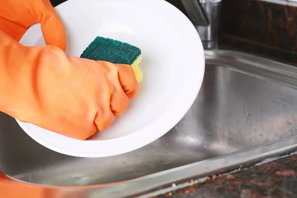 Manos en guantes de goma lavando platos con spon —  Fotos de Stock