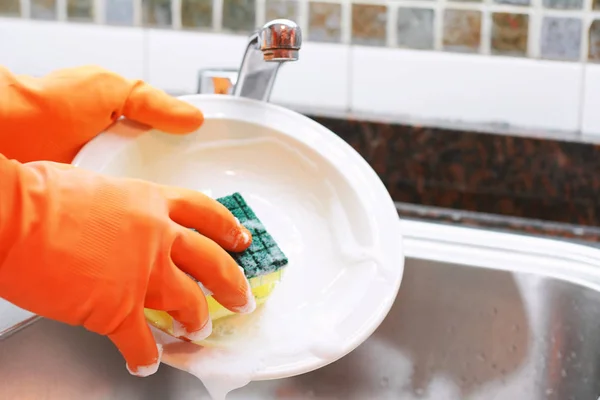 Ręce w rękawiczkach gumowych mycia naczyń z spon — Zdjęcie stockowe