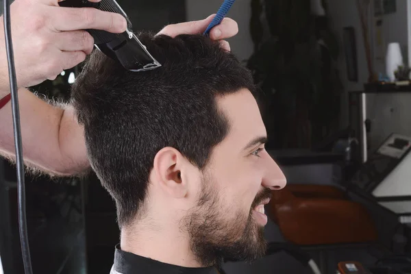 Muž v kadeřnictví s vlasy nůžky. — Stock fotografie