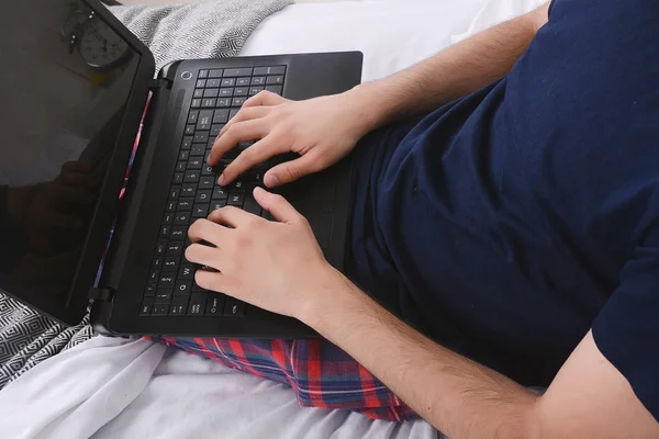 Людина використовує ноутбук у ліжку . — стокове фото
