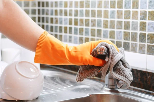 Hand with gloves wiping stainless steel sink with cloth — Stock Photo, Image