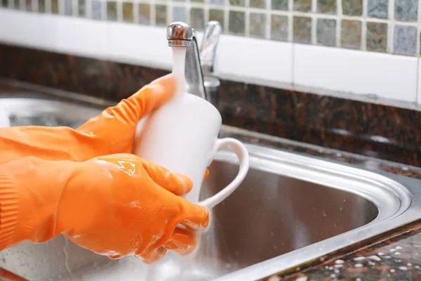 Manos en guantes de goma lavando platos con spon — Foto de Stock