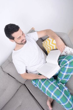 Genç adam kitap okuyor.