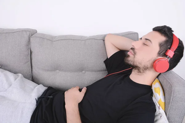 Mann hört Musik auf Couch. — Stockfoto