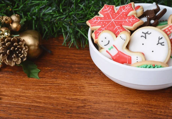 Bolinhos de Natal coloridos em uma tigela com decoração festiva — Fotografia de Stock