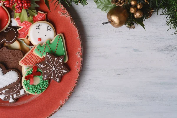 Placa vermelha com biscoitos de Natal coloridos — Fotografia de Stock
