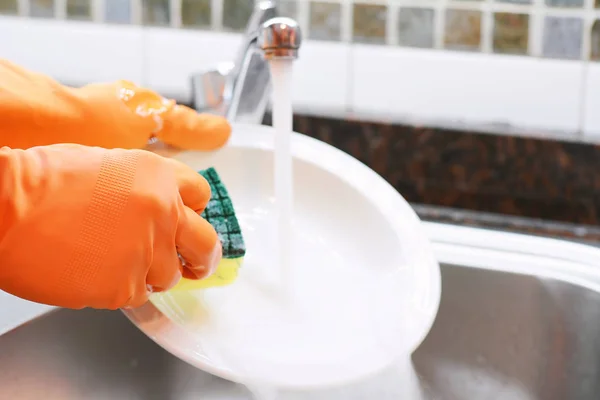 Manos en guantes de goma lavando platos con spon —  Fotos de Stock