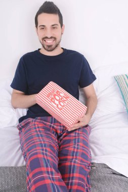 Patlamış mısır yemek ve film izlerken bir adam.