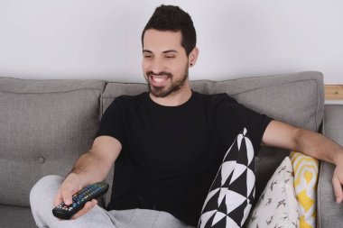 Adam kanepede televizyon izlerken.