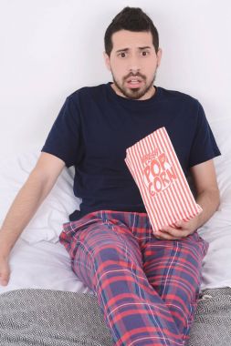 Patlamış mısır yemek ve film izlerken bir adam.