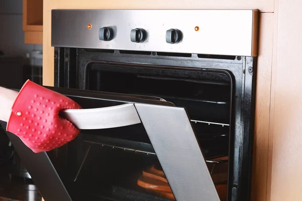 Tomar bandeja horneada del horno con guantes de cocina — Foto de Stock