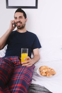 Yatakta telefonda konuşan adam.