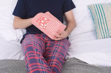 Patlamış mısır yemek ve film izlerken bir adam.