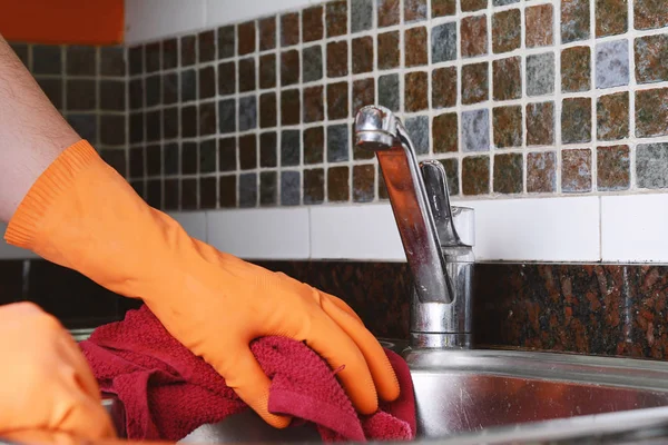 Mano con guantes limpiando fregadero de acero inoxidable con tela —  Fotos de Stock