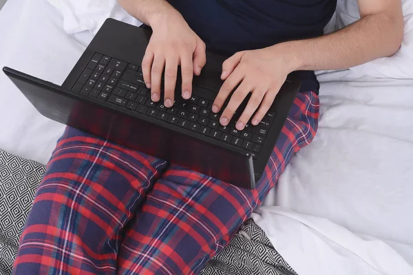 Hombre usando el ordenador portátil en la cama . —  Fotos de Stock