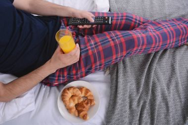 Adam yatakta kahvaltı yapıyor..