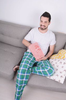 Patlamış mısır yemek ve film izlerken bir adam.