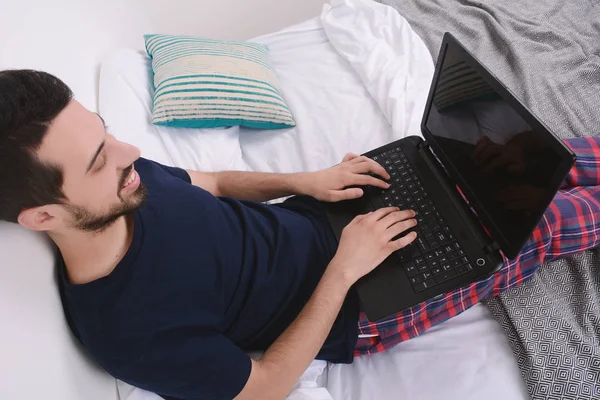 男人在床上使用笔记本电脑. — 图库照片
