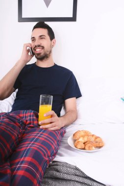 Yatakta telefonda konuşan adam.