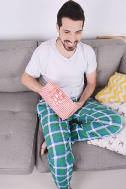 Patlamış mısır yemek ve film izlerken bir adam.