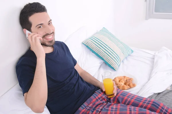 Homme parlant au téléphone au lit . — Photo