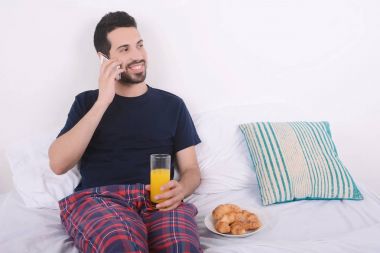 Yatakta telefonda konuşan adam.