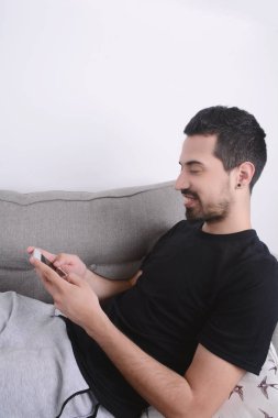 Kanepeye Smartphone kullanan adam.