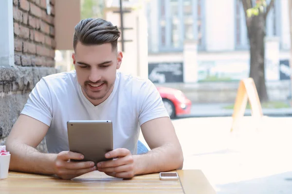 Young man in coffee shop cafe using a tablet. — Stock Photo, Image
