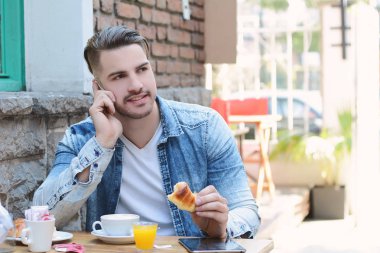 Telefonda konuşurken kafede genç adam. 