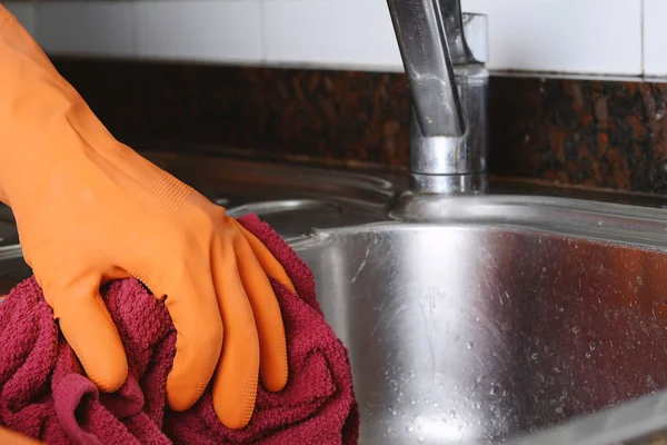 Mano con guantes limpiando fregadero de acero inoxidable con tela —  Fotos de Stock