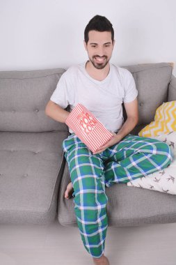 Patlamış mısır yemek ve film izlerken bir adam.