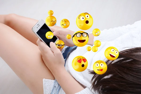 Frau mit Smartphone verschickt Emojis. — Stockfoto