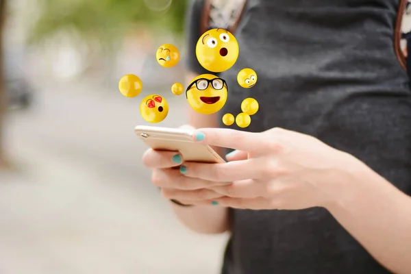 Kvinna med smartphone skicka emojis. — Stockfoto
