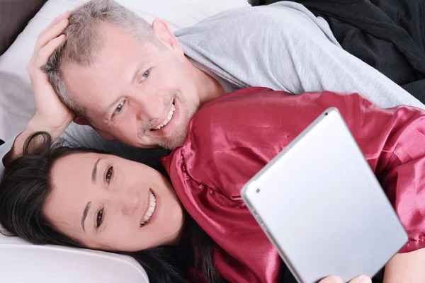 快乐的 middle-aged 夫妇在家看视频平板电脑. — 图库照片
