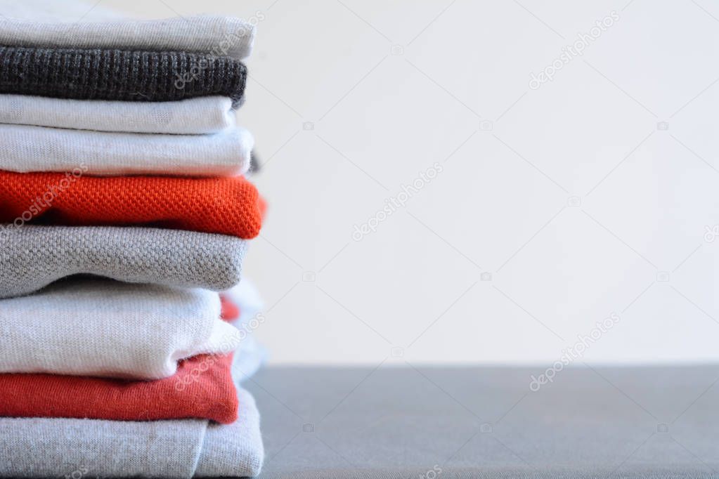 Stack of colorful folded shirts on gray table 