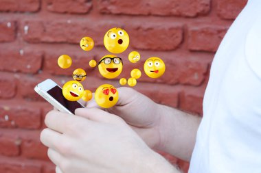 Emojis gönderme smartphone kullanan adam.