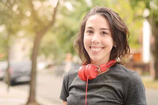 Retrato de una joven hermosa mujer con auriculares rojos escuchando — Foto de Stock
