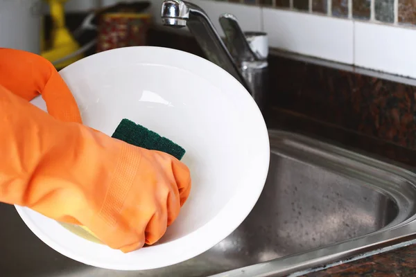 Manos en guantes de goma lavando platos con spon — Foto de Stock