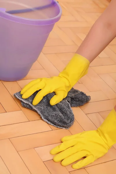 Close up of woman cleaning the floor with cloth. Indoors. Housework concept