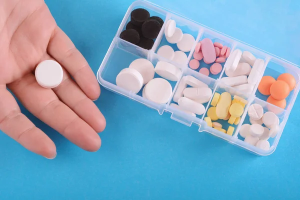 Fechar Mão Mostrando Pílula Com Caixa Remédio Fundo Azul — Fotografia de Stock