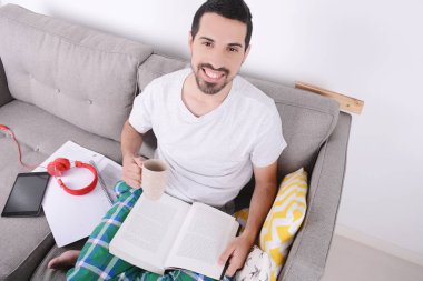 Fincan kahve ile eğitim çekici genç adam. Kapalı.