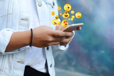 Woman using smartphone sending emojis. clipart