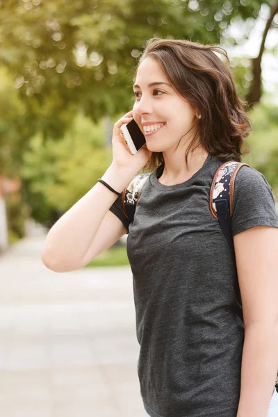 Porträt einer jungen schönen Frau, die mit ihrem Smartphone spricht — Stockfoto