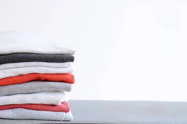 Montón de camisas plegadas de colores en la mesa gris — Foto de Stock